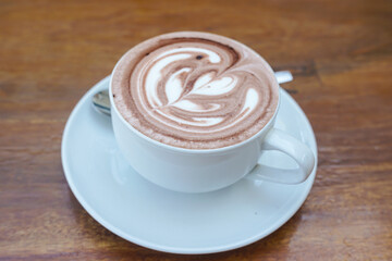 A cup of coffee with latte art on a wooden table