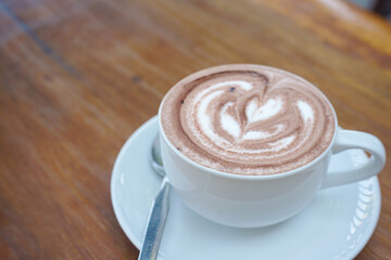 A cup of coffee with latte art on a wooden table