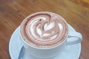 A cup of coffee with latte art on a wooden table