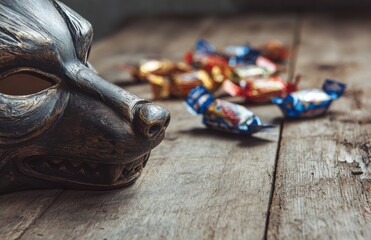 Close-Up of Werewolf Mask on Rustic Table with Candy Wrappers