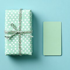 Polka-dot gift & green card on light blue background