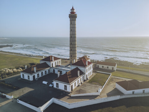 Aerial view of Farol da Boa Nova lighthouse stands tall against the backdrop of the Atlantic ocean, its red cap a beacon, R. Cel. Helder Ribeiro, Matosinhos, Porto, Portugal.