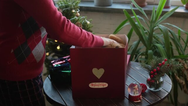 Charity. Christmas donation for children. Volunteer collects toys in donation box 