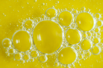Macro photo of multiple transparent yellow bubbles in bright liquid, abstract and minimal...