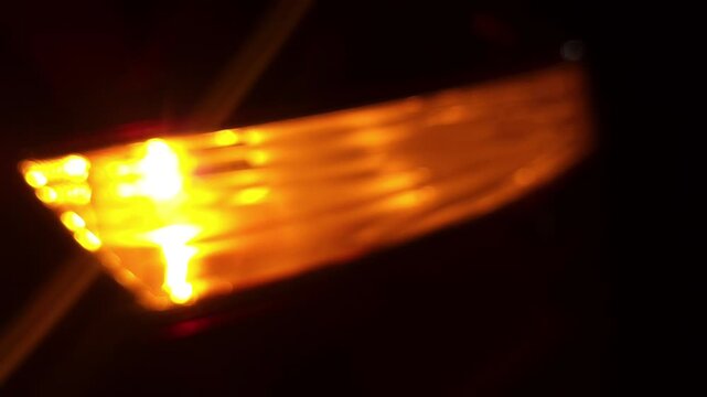 Slow motion Close up of a car's blinker indicating the direction change at night