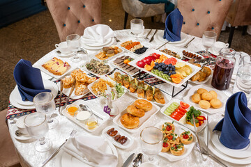 Top view of table with meat, salads, and desserts. Captures the spirit of generosity and hospitality - perfect for catering catalogs and upscale restaurants.