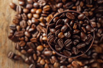 Close-Up of Dark Roasted Coffee Beans in a Brown Bowl on Wood