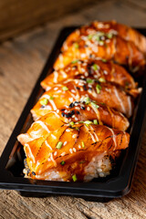 Grilled Salmon Sushi Rolls with Glaze and Garnish on Wooden Background