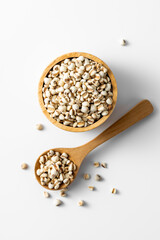 Raw Grains in Wooden Bowl and Spoon on Minimalist White Background