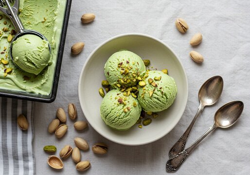 Delicious homemade pistachio ice cream scoops in a white bowl.