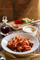 Delicious Rigatoni Pasta with Meat Sauce and Ingredients on Table