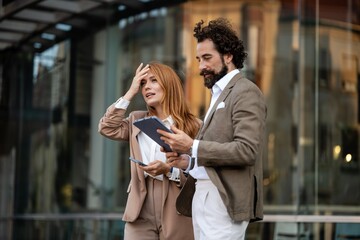 Businesspeople having problems while reading a digital tablet outdoors