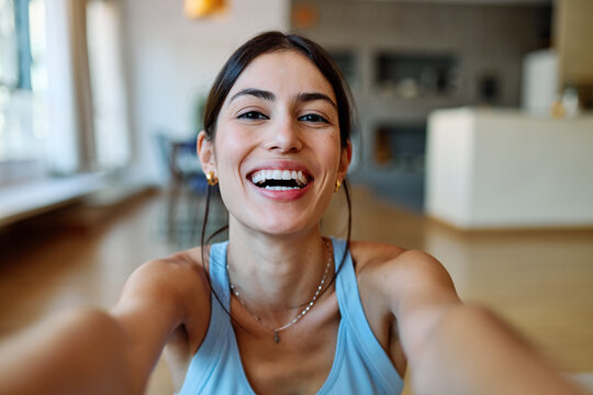 Portrait of a fit blatina girl young woman exercising practicing yoga or fitness taking a selfie with mobile phone camera at home - Powered by Adobe