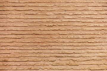 Obraz premium Textured brown earthen wall with horizontal lines pattern