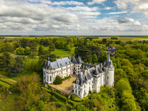Aerial view of Ch&Atilde;&cent;teau de Chaumont, a majestic castle rises amidst vibrant green trees, under a sky with fluffy clouds, Chaumont-sur-Loire, Centre-Val de Loire, France.