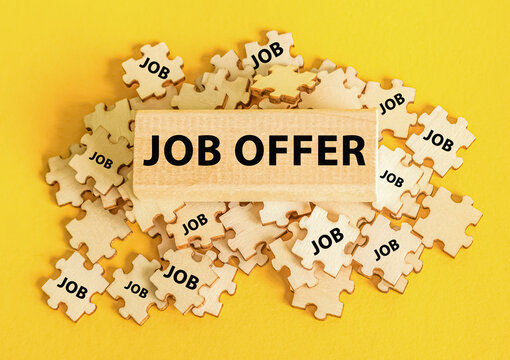 text job offer. A lots of puzzles and a wooden block on a yellow background. Best offers on the labor market. Find employment. Skills, experiences and qualifications.
