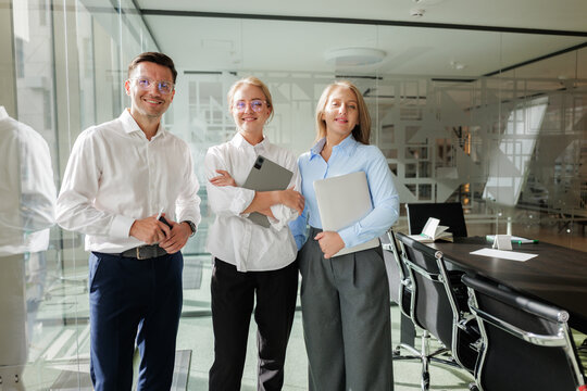 Group of professionals smiling in a modern office setting together