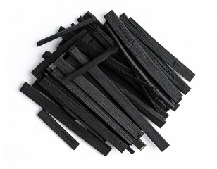 Stack of dark charcoal sticks in irregular heap on white