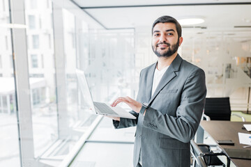 Fototapeta premium Business professional engaged with laptop in modern office setting