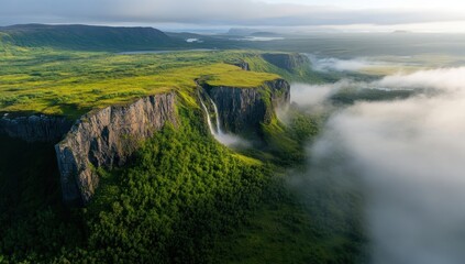 A majestic waterfall cascades down a dramatic cliff face, nestled within a lush green landscape shrouded in morning mist