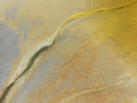 Aerial view of swirling, ochre-stained earth reveals the dramatic textures and mineral-rich landscapes of Minas de Riotinto, Andalusia, Spain.