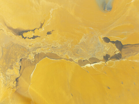 Aerial view of swirling ochre and umber earth tones blend in a surreal landscape, creating a painterly canvas of textures and hues, Minas de Riotinto, Andalusia, Spain.