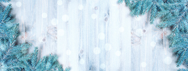 Christmas background. Blue fir tree branches and snowflakes on the wooden background. Christmas...