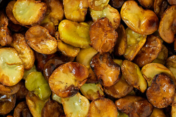 Background texture made of homemade roasted broad beans (Vicia faba). Close-up view.