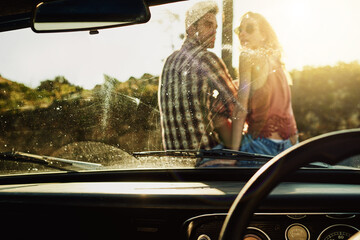 Road trip, car and couple by windshield on holiday, vacation and travel together at sunset. Man, woman and journey by windscreen of vehicle to relax on adventure, tourism and transport window