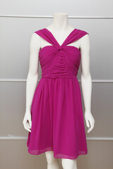 Elegant fuchsia dress displayed on a mannequin against a neutral backdrop.