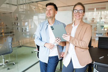 Obraz premium Professionals collaborating in a modern office setting with digital tablet