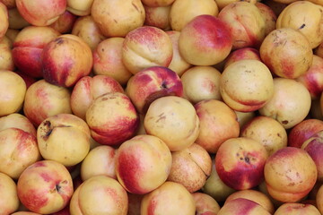 Fresh ripe nectarines piled on a market stall