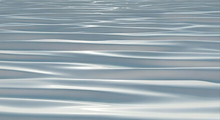 Close-up view of gentle ocean waves with soft blue and white hues reflecting sunlight on the surface.