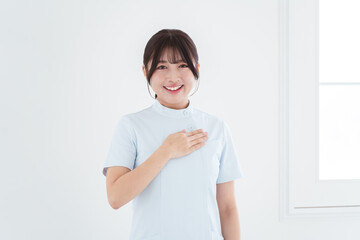 胸に手を当てる笑顔の女性看護師