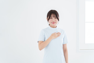 胸に手を当てる笑顔の女性看護師