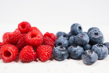 Raspberries and blueberries are a healthy colorful nutritious breakfast or dessert. A closeup shot...