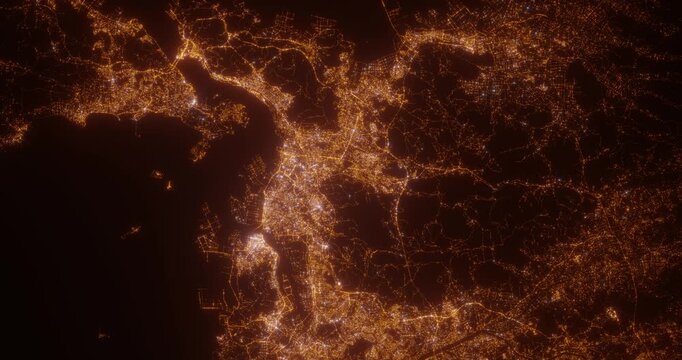 Kitakyushu (Japan) top view at night. Aerial view on modern city from space. Camera is flying above the city, moving forward. Vertical video. The north is on the left side
