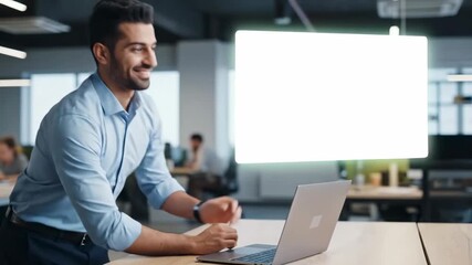 Businessman smiling while working on laptop in bright office space. Clean desk setting with green and white areas for overlay text. Concept of corporate, marketing, entrepreneurship - Powered by Adobe