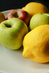 Assorted apples and lemons on plate