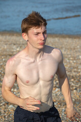 Obraz premium Teenage Shirtless Boy Jogging Towards On A Beach