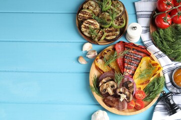Vegetarian barbecue. Tasty grilled vegetables and mushrooms served on light blue wooden table, flat lay. Space for text
