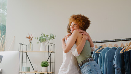 Two Women Celebrating Successful Order For Their Online Fashion Business From Home Together