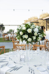 Elegant outdoor wedding reception table with white floral centerpiece
