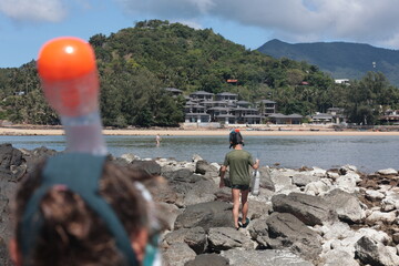 Children exploring rocky shore with snorkeling masks, Koh Phangan, Thailand