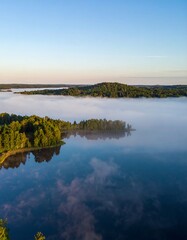 Sunlit Fog over a Calm Lake and Green Forest
