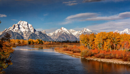 Dramatic Autumn Foliage In The Grand Tetons In Wyoming As Yellow Colored Trees Peaceful Snake River And Snow Capped Mountains Fill The Background