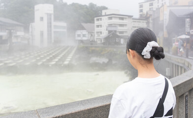 草津温泉旅行で湯畑に来ている10代の女性