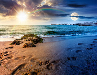 sunrise on a sandy town beach on equinox season. day and night time change concept. beautiful and warm weather on the shores of black sea. coast with sun and moon at twilight © Pellinni