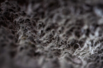 Extreme close up of old gray handmade paper clay with a structure and rough texture. Paper recycling. Selective soft focus, shallow depth of field.