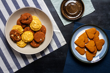 Bowl and plate with cookies on black chalkboard texture. Flat lay. Top view. Food concept.
